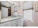 Bright bathroom featuring a single sink vanity, framed mirror, white cabinets, and a window for natural light at 3410 Pecos St, Denver, CO 80211