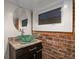 Industrial style bathroom with a decorative vessel sink and exposed brick at 3410 Pecos St, Denver, CO 80211