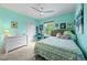 This cozy bedroom features bright teal walls, a ceiling fan, and natural light from the window at 3410 Pecos St, Denver, CO 80211