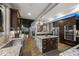 Open kitchen features dark cabinets, granite countertops, stainless steel appliances, and an island at 3410 Pecos St, Denver, CO 80211