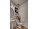 Cozy bathroom with pedestal sink, decorative mirror, toilet and hardwood style floor at 4505 Cholla Trl, Castle Rock, CO 80104