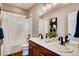 Bright bathroom with dual vanity, modern fixtures, and a shower-tub combination with white tile at 13794 Honey Hush Trl, Parker, CO 80134