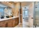 Elegant bathroom with double sink vanity and view into bedroom with neutral colors and decor at 13794 Honey Hush Trl, Parker, CO 80134