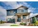 Charming two-story home with a covered porch and stone accents, creating a welcoming curb appeal at 13794 Honey Hush Trl, Parker, CO 80134