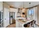 Modern kitchen featuring white cabinets, stainless steel appliances, and a granite island with bar seating at 13794 Honey Hush Trl, Parker, CO 80134