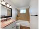 Bathroom featuring a vanity with a granite countertop, bathtub with a tiled surround, and modern fixtures at 12238 Monroe Dr, Thornton, CO 80241