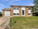 Inviting home showcasing brick facade, well-kept lawn, and an attached garage with ample driveway space at 12238 Monroe Dr, Thornton, CO 80241