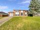 Traditional brick home featuring an attached garage, well-manicured lawn, and mature trees at 12238 Monroe Dr, Thornton, CO 80241