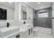 Sleek bathroom with dual sinks, modern lighting, and subway tile, with tub and shower combination at 2202 S Grape St, Denver, CO 80222