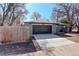Exterior view of a grey brick home featuring a spacious driveway and a two-car garage at 2202 S Grape St, Denver, CO 80222