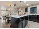 Modern kitchen with island, dark cabinetry, and quartz countertops at 11208 Eagle Creek Cir, Commerce City, CO 80022