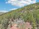 Aerial view of a home nestled amongst the forest, set against a mountain backdrop at 13314 Spruce Creek Cir, Larkspur, CO 80118