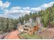 Stunning aerial view of the home nestled amongst a mature forest, on a beautifully landscaped lot at 13314 Spruce Creek Cir, Larkspur, CO 80118