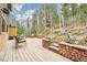 The home's elevated back deck offers peaceful views of trees and a rock retaining wall at 13314 Spruce Creek Cir, Larkspur, CO 80118