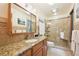 Bathroom vanity features granite countertop, glass shower, and tiled walls at 13314 Spruce Creek Cir, Larkspur, CO 80118