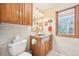 Bathroom features a vanity with granite countertops, wood cabinets, and updated fixtures at 13314 Spruce Creek Cir, Larkspur, CO 80118