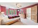 Bedroom featuring an accent wall, multiple windows, ceiling fan, and doorway to a hallway at 13314 Spruce Creek Cir, Larkspur, CO 80118