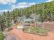 Front exterior of a multi-story home surrounded by trees and vegetation at 13314 Spruce Creek Cir, Larkspur, CO 80118