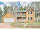 Charming two-story home with a front porch, attached garage, and beautifully landscaped front yard at 13314 Spruce Creek Cir, Larkspur, CO 80118