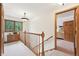 Bright hallway with wood trim, a window view, neutral carpet, and an open doorway at 13314 Spruce Creek Cir, Larkspur, CO 80118