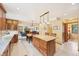 Open kitchen features granite counters, wood cabinets, island with seating, and view to the living room with fireplace at 13314 Spruce Creek Cir, Larkspur, CO 80118