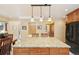 Bright kitchen with large granite island, bar stool seating, and appliances at 13314 Spruce Creek Cir, Larkspur, CO 80118