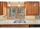 Kitchen sink and granite countertops with view of the backyard deck and wooded area at 13314 Spruce Creek Cir, Larkspur, CO 80118