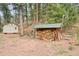 View of shed with firewood storage area on expansive property surrounded by mature trees at 13314 Spruce Creek Cir, Larkspur, CO 80118
