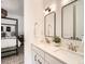 Bathroom with double sinks, quartz countertop, black hardware, and a view of the main bedroom at 15771 W Eureka Ave, Morrison, CO 80465