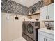 Bright laundry room with washer, dryer, and stylish built-in shelving at 15771 W Eureka Ave, Morrison, CO 80465