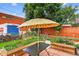 Backyard table and chairs shaded by a yellow umbrella on the patio with raised beds at 274 S Lincoln St, Denver, CO 80209