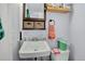 Compact bathroom with a white sink, woven storage baskets and a framed mirror at 274 S Lincoln St, Denver, CO 80209