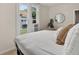 Bright bedroom featuring a comfortable bed, natural light, and a decorative round mirror at 274 S Lincoln St, Denver, CO 80209