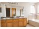 Bright bathroom featuring double sinks, a soaking tub, and tiled accents at 12490 Kearney Cir, Thornton, CO 80602