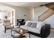 Inviting living room with modern seating, staircase, and archway into dining area at 12490 Kearney Cir, Thornton, CO 80602