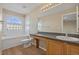Bright bathroom features a tub with unique window, and a wood floor at 20781 E 48Th Pl, Denver, CO 80249