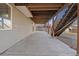 A concrete patio underneath a wooden deck, stairs lead to a backyard at 20781 E 48Th Pl, Denver, CO 80249