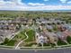 Expansive aerial view of a residential area with numerous homes, green spaces, and winding streets at 21682 E Stroll Ave, Parker, CO 80138