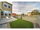 Backyard with a white lattice fence, synthetic grass, and a concrete patio with chairs at 21682 E Stroll Ave, Parker, CO 80138