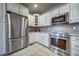 Well-lit kitchen with stainless steel appliances, white cabinets, and tile flooring at 21682 E Stroll Ave, Parker, CO 80138