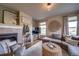Comfortable living room featuring a corner fireplace, neutral paint, and lots of natural light at 21682 E Stroll Ave, Parker, CO 80138