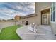 Back patio with white Adirondack chairs on a striped rug with a grill and synthetic grass at 21682 E Stroll Ave, Parker, CO 80138