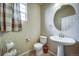 Stylish powder room with pedestal sink, oval mirror, and decorative accents at 21682 E Stroll Ave, Parker, CO 80138