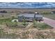 Aerial shot of the home showcasing the house and its surrounding grassy landscape at 6957 Black Forest Dr, Elizabeth, CO 80107