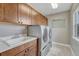 Functional laundry room featuring ample cabinet space, a utility sink, and modern washer and dryer at 6957 Black Forest Dr, Elizabeth, CO 80107