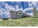 Beautiful two-story home boasts a spacious balcony, manicured lawn, and partially covered lower patio at 6957 Black Forest Dr, Elizabeth, CO 80107