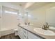 Bright bathroom featuring a double sink vanity and a bathtub with white tile surround at 9544 Pitkin St, Commerce City, CO 80022