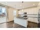 Bright kitchen with an island, white cabinets, granite countertops, and stainless appliances at 9544 Pitkin St, Commerce City, CO 80022