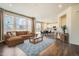 Bright living room with hardwood floors, a large window and open floor plan to kitchen at 9544 Pitkin St, Commerce City, CO 80022