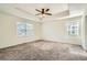 Bright main bedroom showcasing a tray ceiling, large windows, and plush carpeting at 9544 Pitkin St, Commerce City, CO 80022